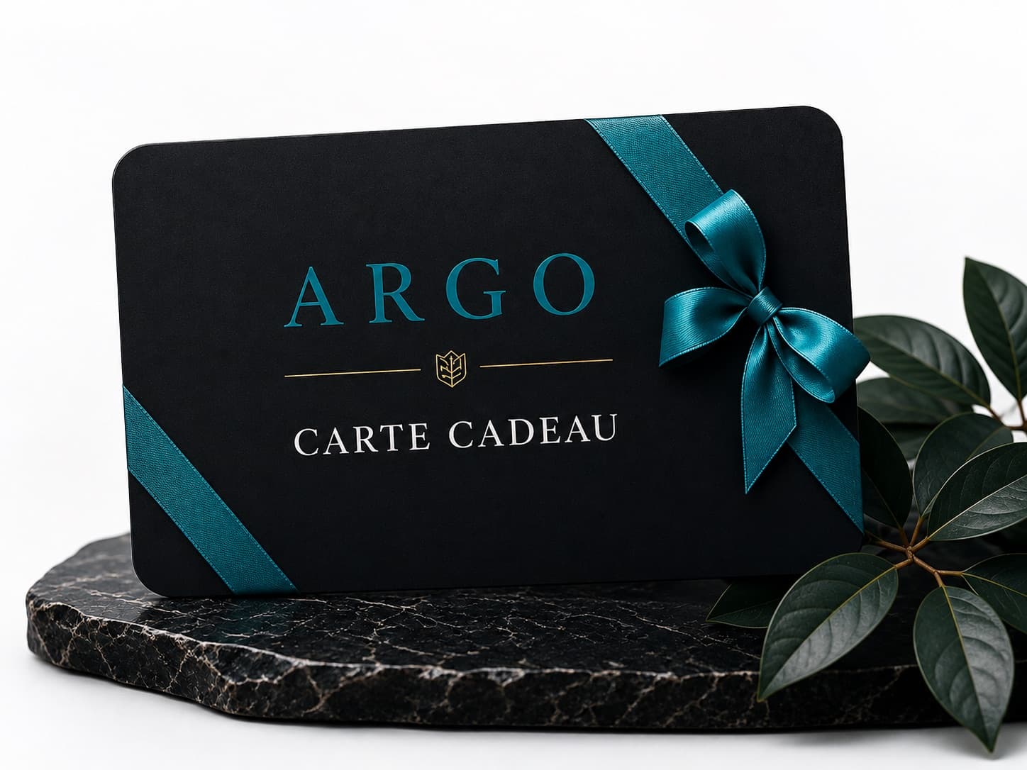 La carte cadeau ARGO nouée d'un ruban teal, posée sur une pierre sombre.